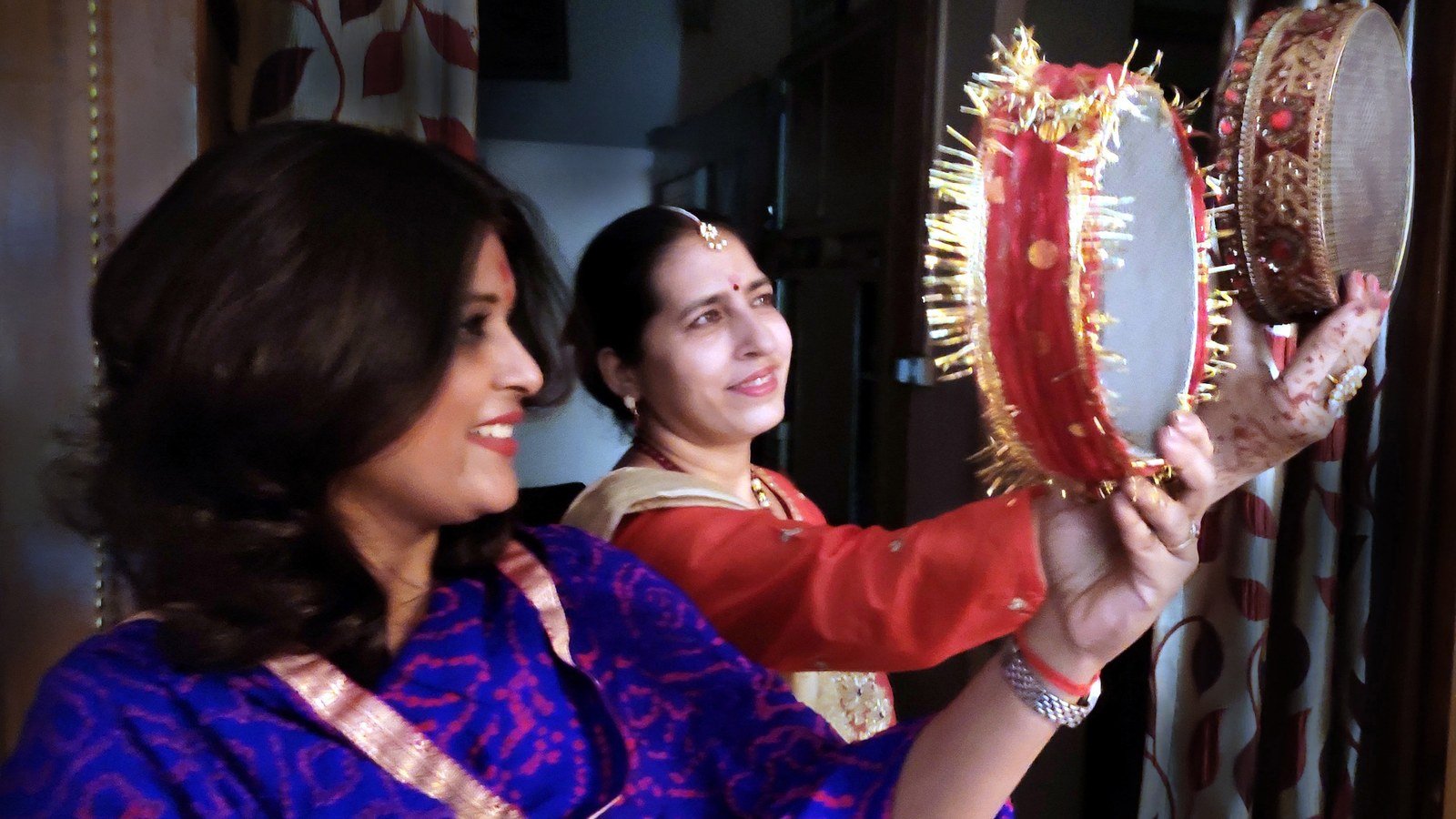 Married woman viewing the moon through a decorated sieve on Karwa Chauth